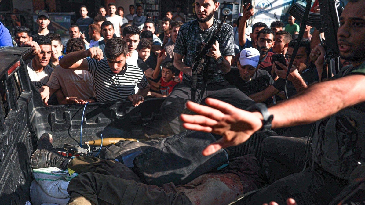 Un grupo de palestinos rodean una furgoneta con supuestos cuerpos de soldados israelíes