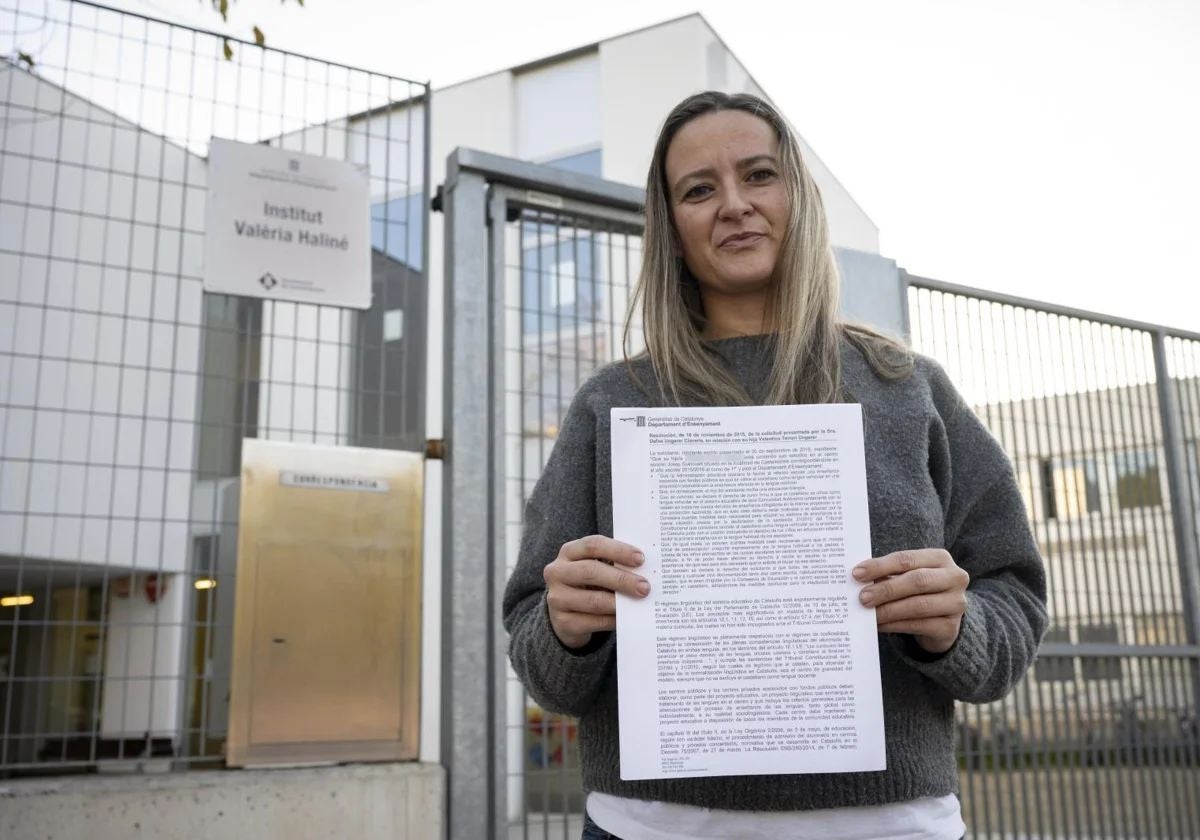 Dafne Ungerer muestra la sentencia que concede más castellano a su hija, frente al instituto de Castelldefels