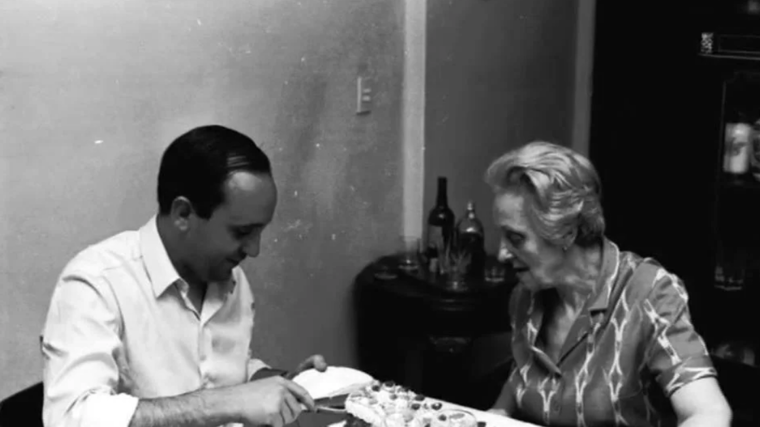 Un joven Francisco corta un trozo de tarta junto a su madre Regina