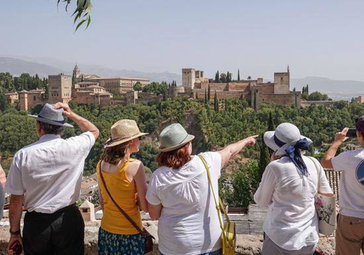 Un grupo de turistas observa la Alhambra desde un mirador