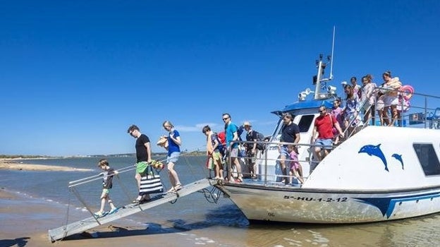 Viajeros bajando del ferry que lleva a la Flecha de El Rompido