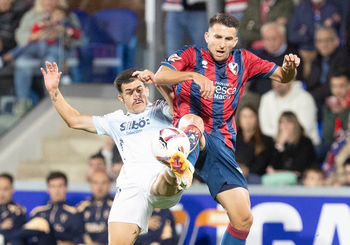 Gerard Valentín pugna con un balón con Matos durante el Huesca - Cádiz.